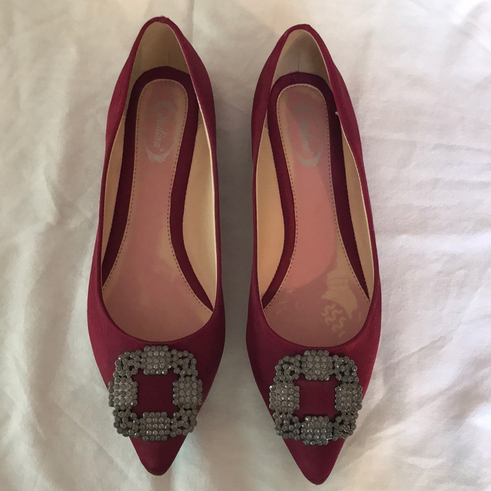 Deep red slip ons with jeweled broach on the toe